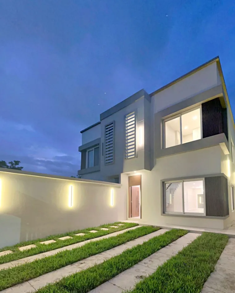Fachada de townhouse en Jardines del Valle al anochecer